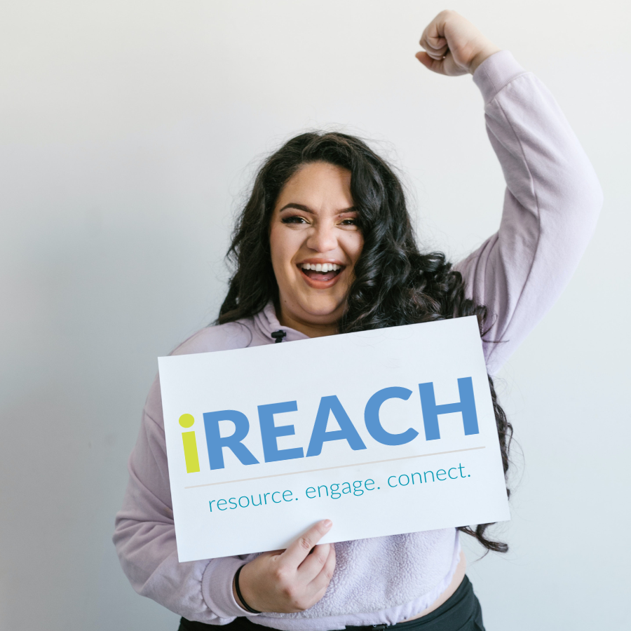 woman holds sign saying ireach resource engage connect with her arm raised